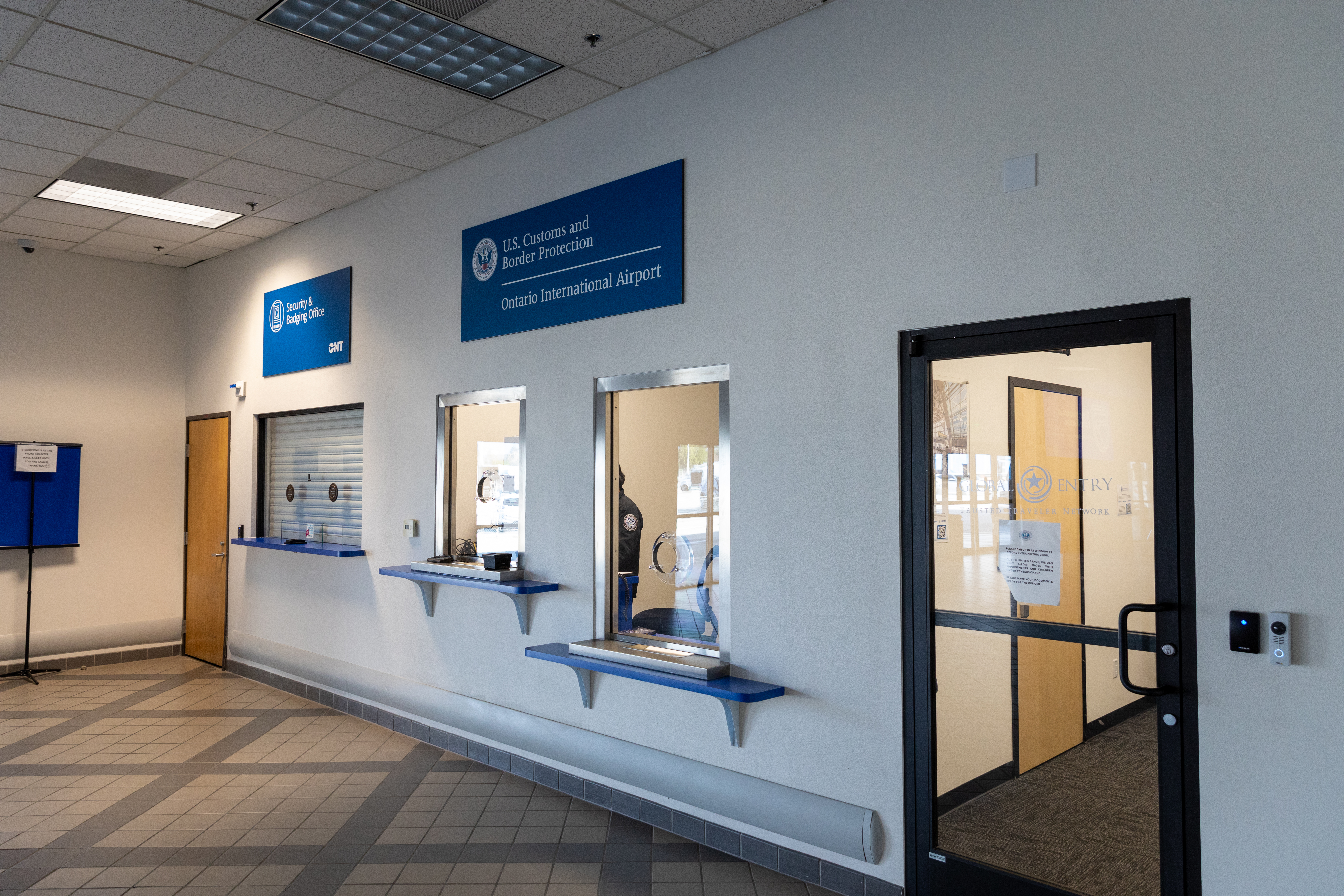 Interior hallway with service windows and a doorway in an office or institutional building.