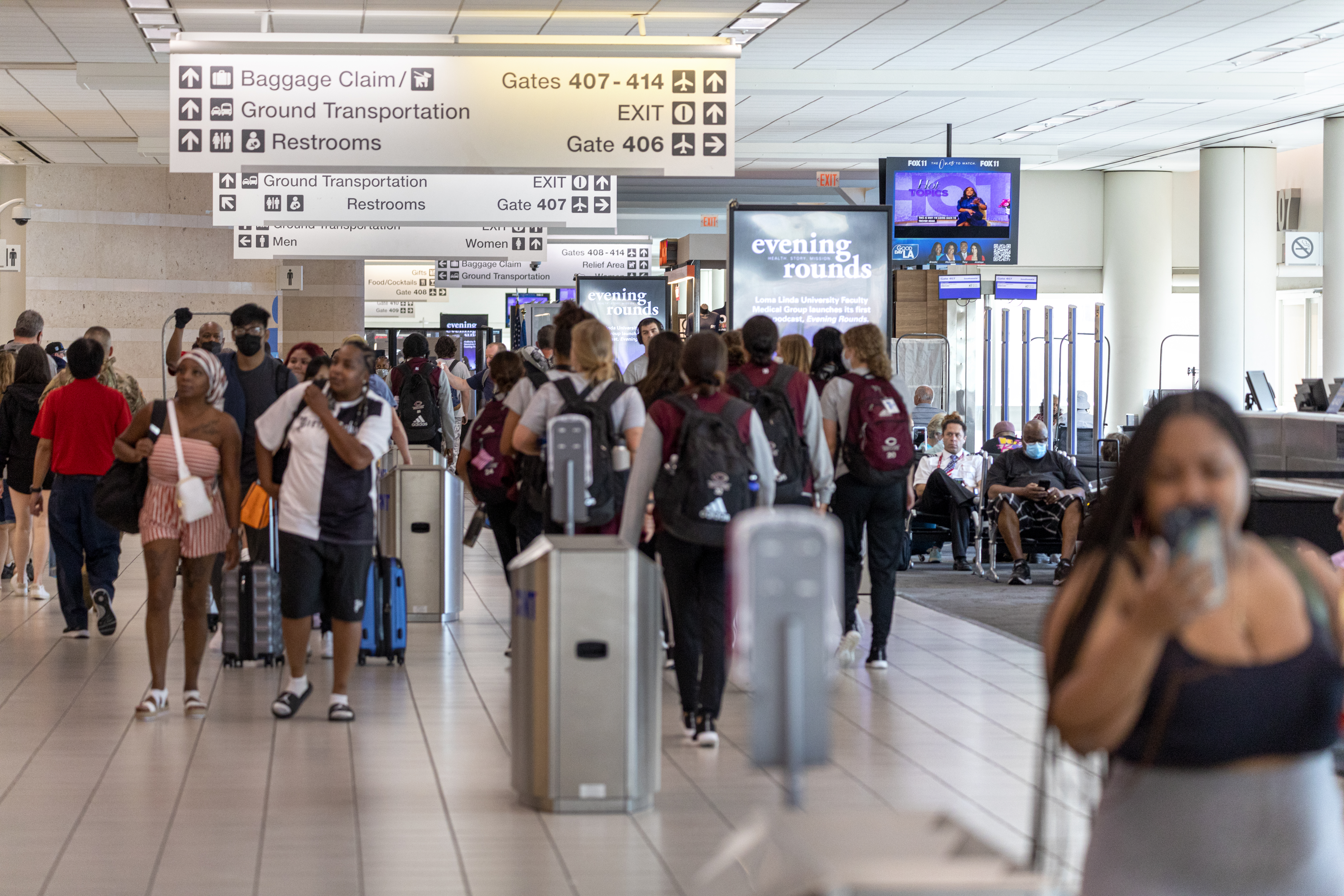 Busy airport terminal with travelers entering through ticket gates