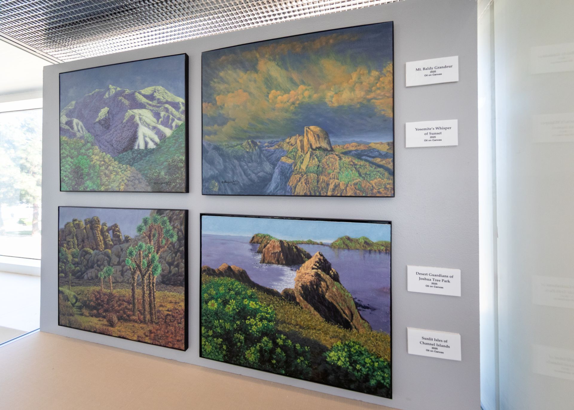 Four paintings show landscapes around Southern California, including mountains and beaches.