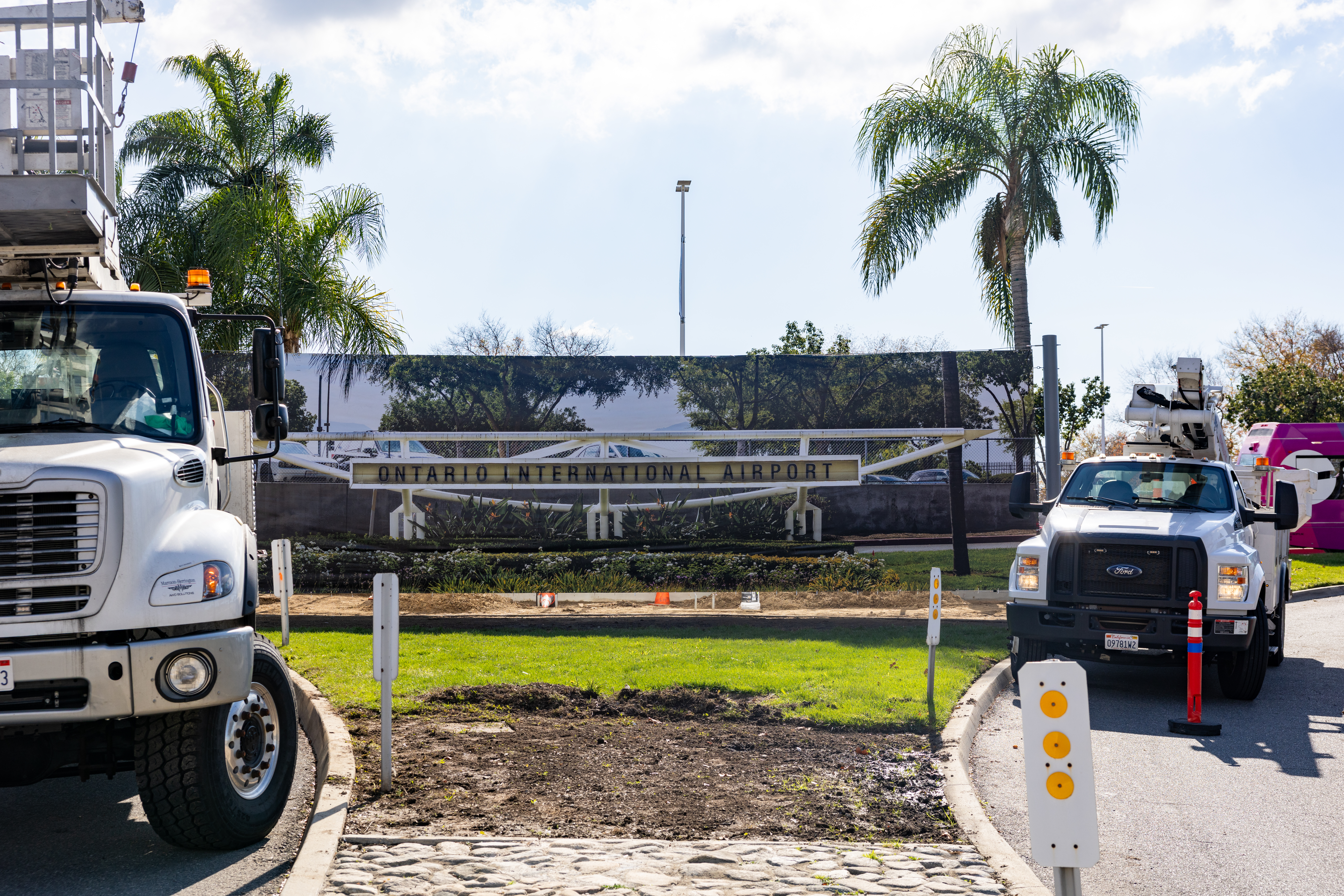 a large banner is stretched across the monument sign area while construction is happening. The banner has a photo of the mid century monument sign that was replaced