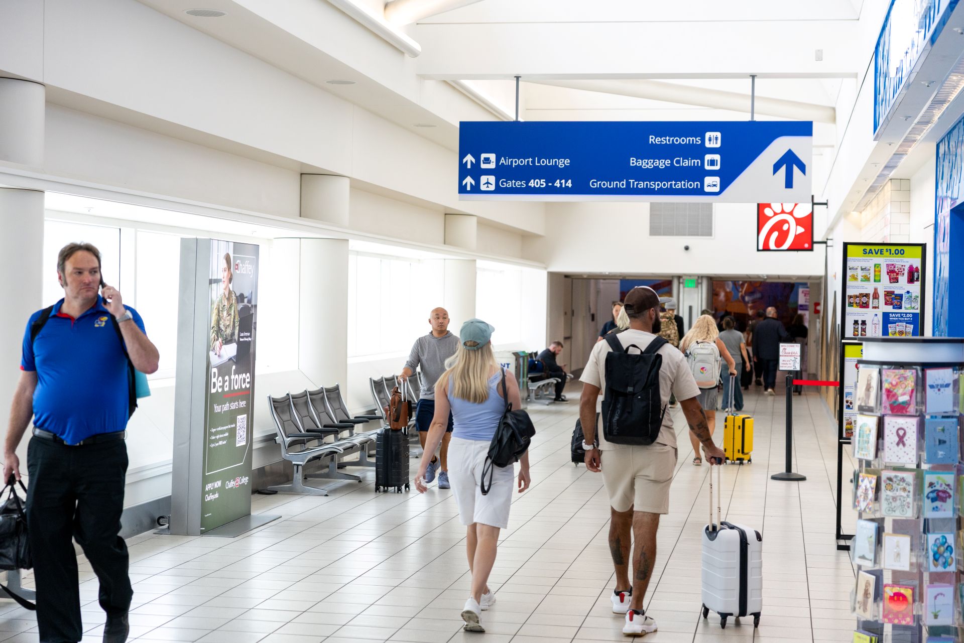 A man walks toward the camera while a couple walks away through the ONT terminal.