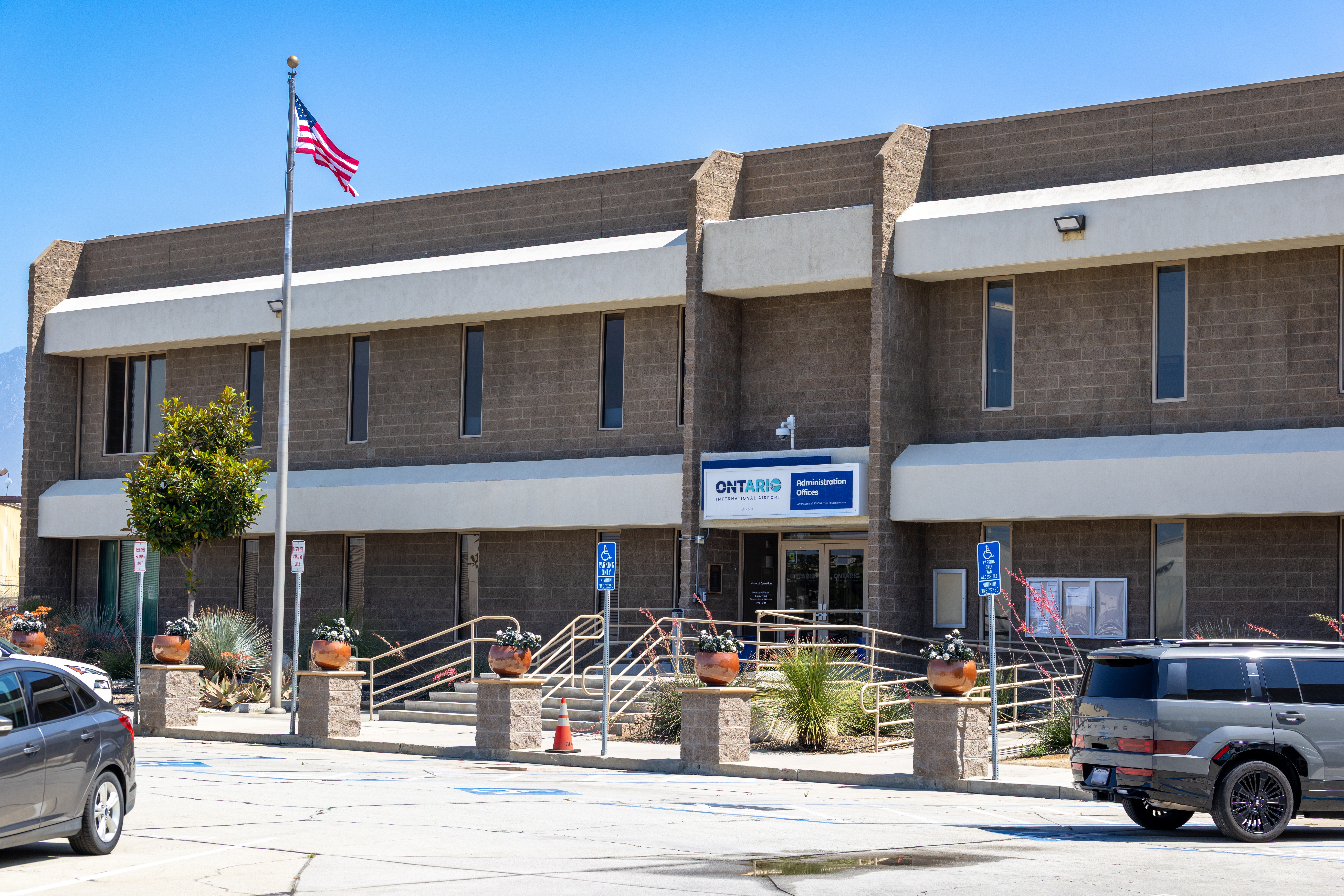 Two-story commercial building with American flag and parking spaces in front