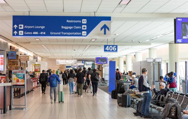 Airport terminal with passengers walking past gates and seating areas