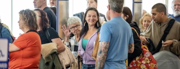 A diverse group of people gathered indoors, engaged in conversation at a social event.