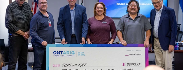Group of people presenting a large ceremonial check at an Ontario Lottery event.