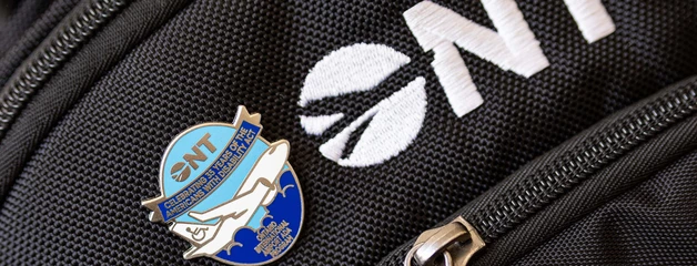 ONT logo and a blue enamel pin on a black backpack.