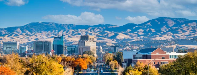 Boise skyline with vibrant golden autumn trees and mountains in background.