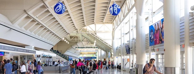 Photo of baggage claim area and check in at the airport terminal with holiday decor 