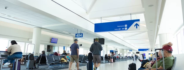 Passengers seated near a gate 404 with their luggage. 