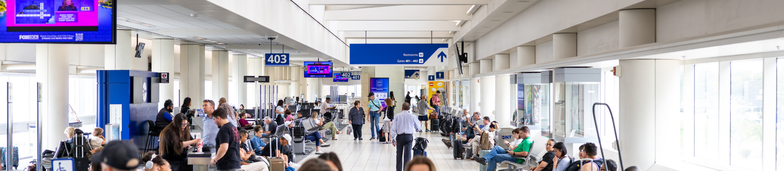 Group of people walking though the terminal with baggage. 