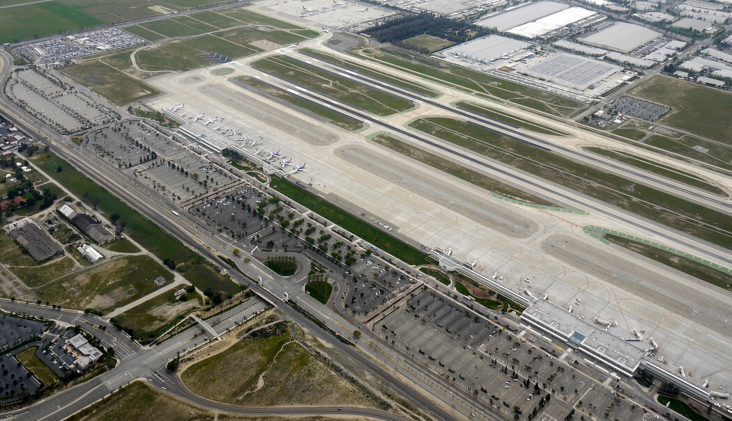 Aerial view of an airport runway with surrounding infrastructure and roads.