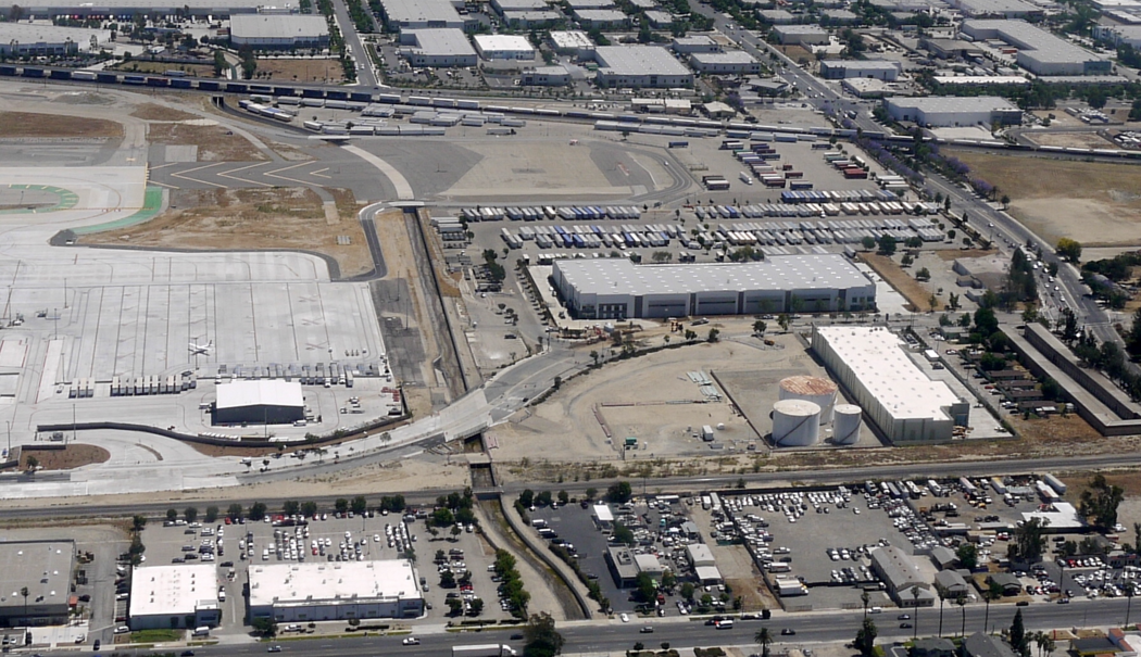 Aerial view of industrial area with warehouses and commercial buildings surrounded by roads.